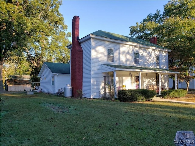 13404 Queen St, Disputanta, VA 23842 - view of front of house with a chimney, a front yard, and covered porch