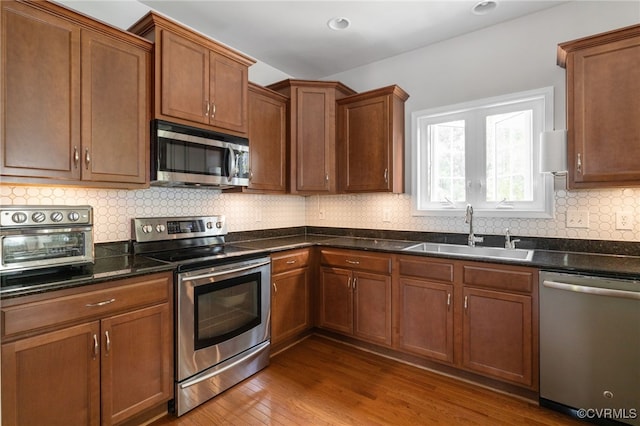 14300 Wallingham Loop, Midlothian, VA 23114 - kitchen featuring appliances with stainless steel finishes, a sink, wood finished floors, tasteful backsplash, and recessed lighting