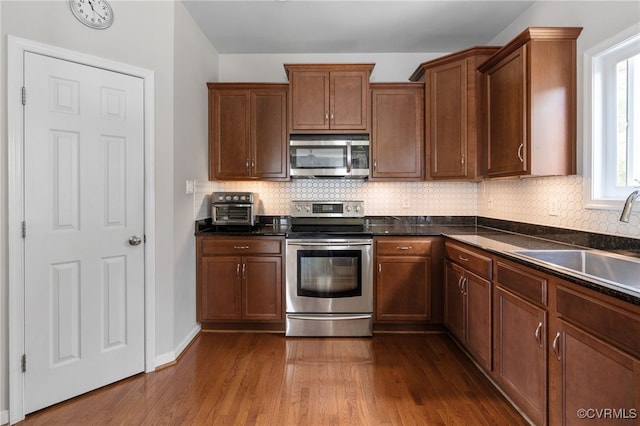 14300 Wallingham Loop, Midlothian, VA 23114 - kitchen featuring appliances with stainless steel finishes, a sink, dark countertops, and backsplash