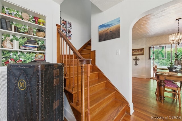 290 Circle Dr, Port Haywood, VA 23138 - stairs featuring arched walkways, a chandelier, and wood finished floors