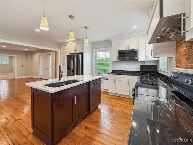 29898 The Trl, Shacklefords, VA 23110 - kitchen with stainless steel appliances, wall chimney exhaust hood, a sink, white cabinets, and an island with sink