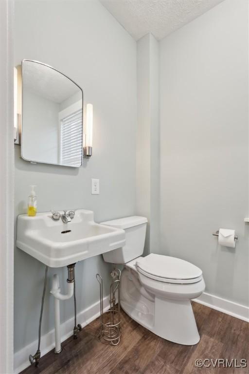29898 The Trl, Shacklefords, VA 23110 - bathroom with toilet, wood finished floors, baseboards, and a textured ceiling