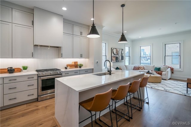 425 W 7th St, Richmond, VA 23224 - kitchen featuring stainless steel gas range, a sink, light wood-style flooring, a kitchen island with sink, and recessed lighting