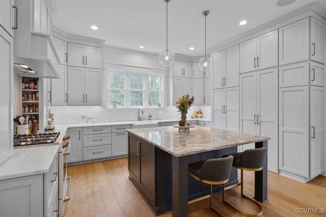 547 River Rd, Manakin Sabot, VA 23103 - kitchen with stainless steel gas stove, decorative backsplash, light stone countertops, a breakfast bar area, and recessed lighting