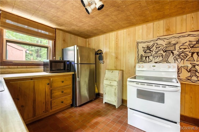 198 Trices Lake Rd, Columbia, VA 23038 - kitchen featuring white range with electric stovetop, black microwave, wood walls, freestanding refrigerator, and light countertops