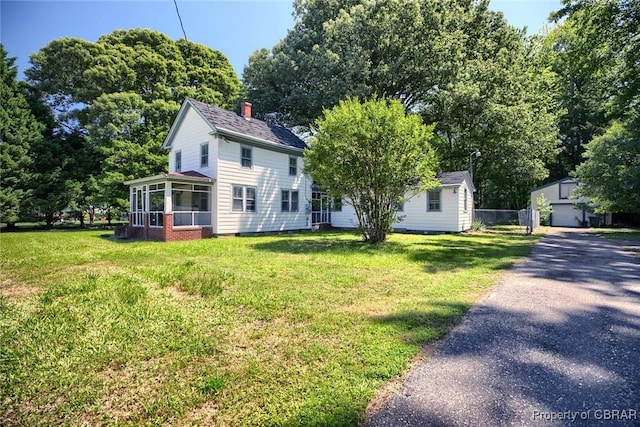 708 Calthrop Neck Rd, Yorktown, VA 23693 - view of front of home featuring a sunroom, a front yard, an outdoor structure, and a chimney
