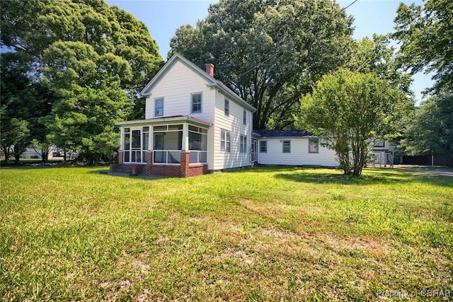 708 Calthrop Neck Rd, Yorktown, VA 23693 - rear view of house with a sunroom, a yard, and a chimney