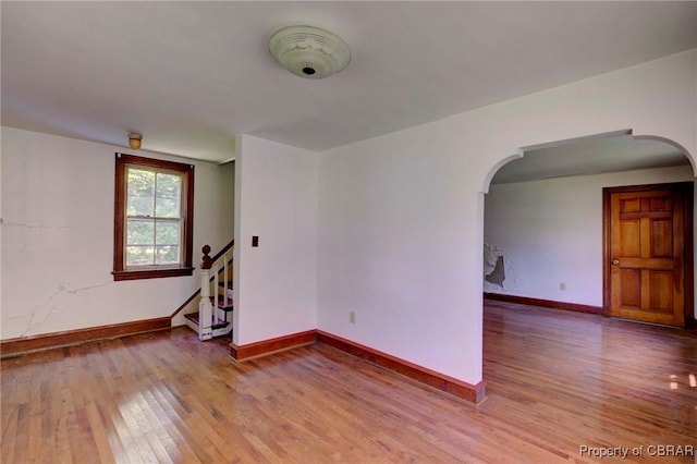 708 Calthrop Neck Rd, Yorktown, VA 23693 - spare room featuring wood finished floors, arched walkways, and stairway