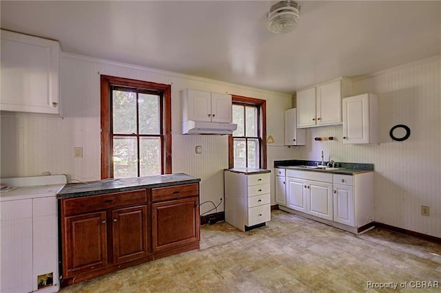 708 Calthrop Neck Rd, Yorktown, VA 23693 - kitchen with washer / dryer, white cabinets, light floors, under cabinet range hood, and ornamental molding