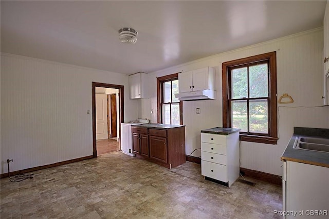 708 Calthrop Neck Rd, Yorktown, VA 23693 - kitchen featuring under cabinet range hood, white cabinetry, tile patterned floors, crown molding, and dark countertops