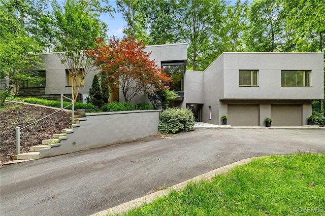 322 Charmian Rd, Richmond, VA 23226 - view of front of home featuring stairs, an attached garage, driveway, and stucco siding