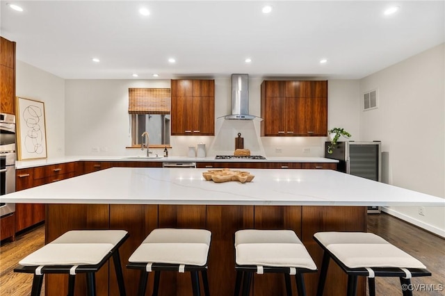 322 Charmian Rd, Richmond, VA 23226 - kitchen with wall chimney range hood, a sink, modern cabinets, wood finished floors, and recessed lighting