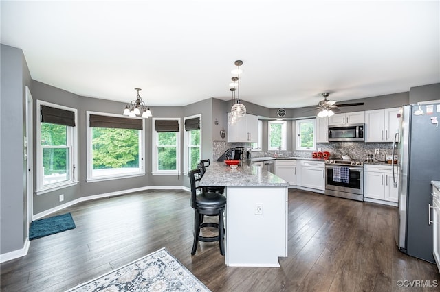 16397 Goshen Rd, Montpelier, VA 23192 - kitchen with stainless steel appliances, a peninsula, a chandelier, white cabinetry, and a sink