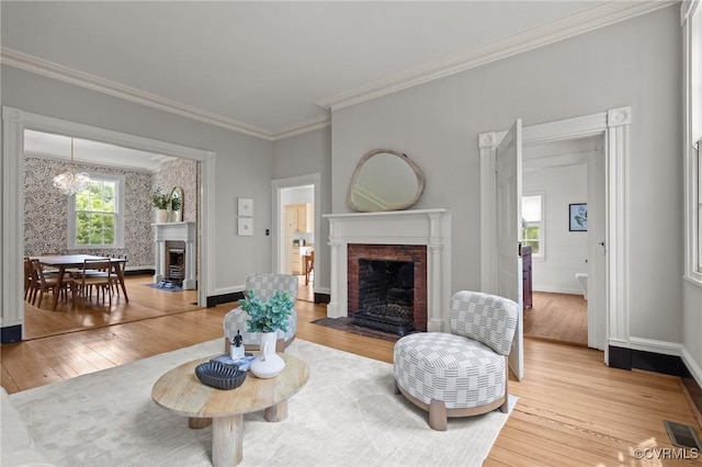 9341 Varina Rd, Henrico, VA 23231 - living room with a brick fireplace, light wood-style flooring, crown molding, baseboards, and a chandelier
