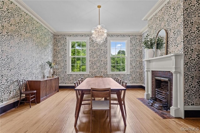 9341 Varina Rd, Henrico, VA 23231 - dining area with crown molding, wallpapered walls, wood-type flooring, a chandelier, and a fireplace with flush hearth