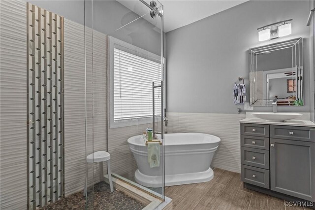 9085 Winter Spring Dr, Mechanicsville, VA 23116 - bathroom with tile walls, a shower stall, vanity, a freestanding tub, and a wainscoted wall