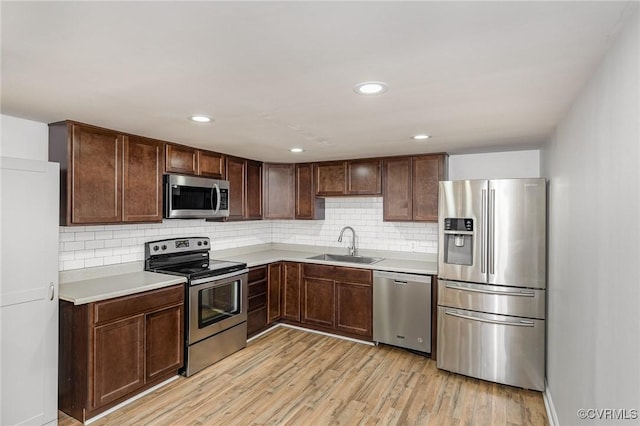 3027 Supply Rd, Port Royal, VA 22436 - kitchen with stainless steel appliances, a sink, light countertops, light wood finished floors, and backsplash