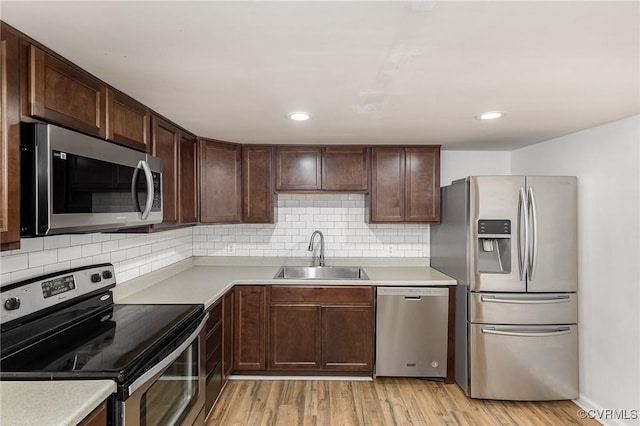 3027 Supply Rd, Port Royal, VA 22436 - kitchen featuring appliances with stainless steel finishes, a sink, light wood finished floors, tasteful backsplash, and recessed lighting