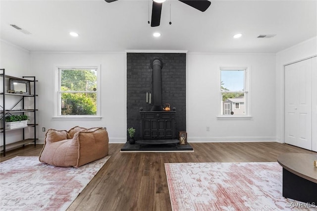 1311 Dinwiddie Ave, Hopewell, VA 23860 - living room featuring a wood stove, ornamental molding, wood finished floors, a ceiling fan, and recessed lighting