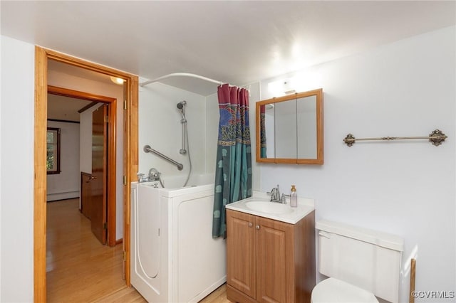 6495 Robin Way, Mechanicsville, VA 23111 - bathroom featuring a baseboard heating unit, washer / clothes dryer, vanity, toilet, and shower / tub combo with curtain