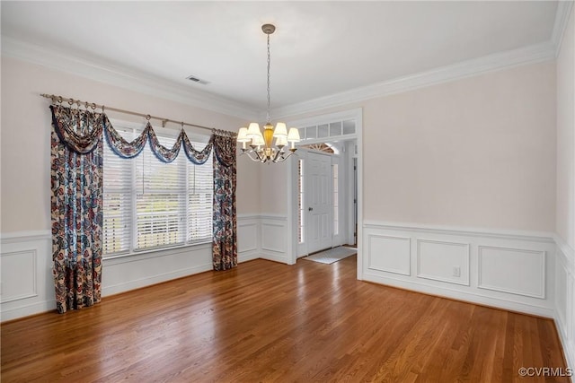 4905 Old Millrace Pl, Glen Allen, VA 23059 - unfurnished dining area with a chandelier, a decorative wall, wood finished floors, ornamental molding, and wainscoting