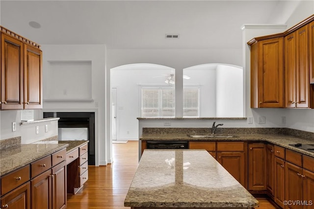 4905 Old Millrace Pl, Glen Allen, VA 23059 - kitchen featuring a sink, a ceiling fan, light stone countertops, a kitchen island, and light wood-type flooring