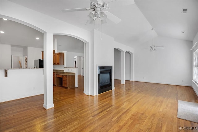 4905 Old Millrace Pl, Glen Allen, VA 23059 - unfurnished living room with ceiling fan, a multi sided fireplace, light wood-style flooring, vaulted ceiling, and recessed lighting