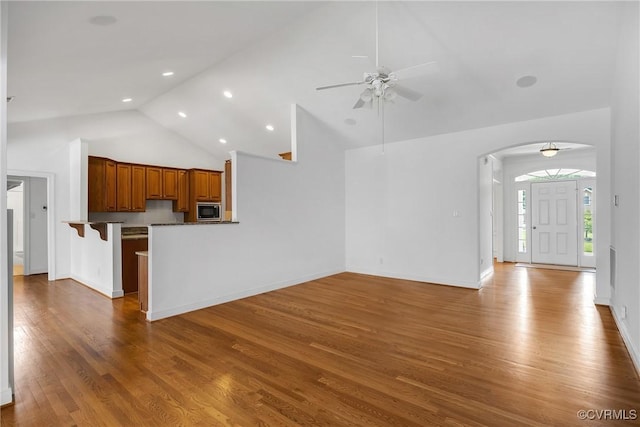 4905 Old Millrace Pl, Glen Allen, VA 23059 - unfurnished living room featuring a ceiling fan, arched walkways, wood finished floors, high vaulted ceiling, and baseboards