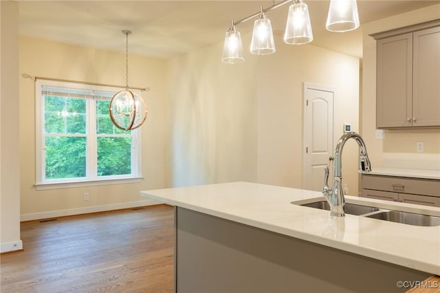207 Eliza Ln, Aylett, VA 23009 - kitchen with gray cabinets, a sink, light wood-style flooring, and a chandelier