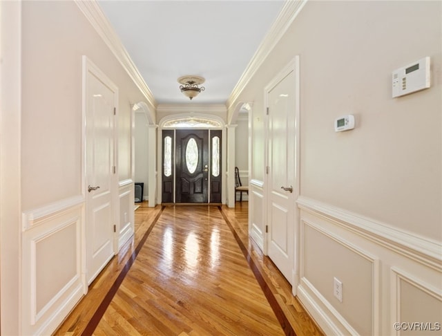 2220 French Hill Ter, Powhatan, VA 23139 - foyer entrance with light wood finished floors, ornamental molding, arched walkways, wainscoting, and a decorative wall
