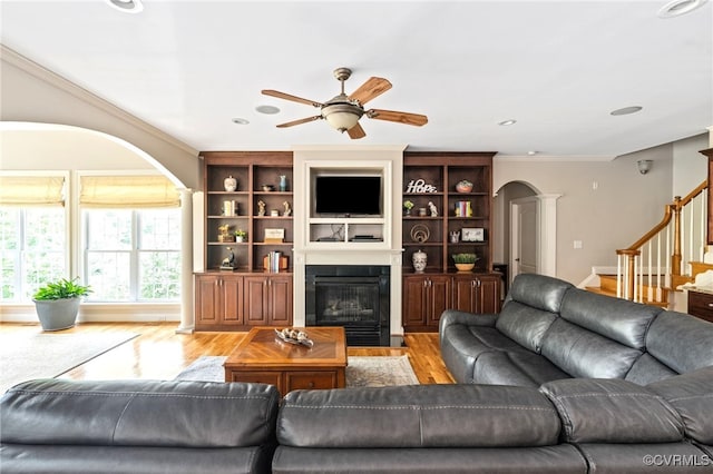 2220 French Hill Ter, Powhatan, VA 23139 - living area with arched walkways, a ceiling fan, a fireplace with flush hearth, ornamental molding, and light wood-type flooring