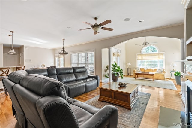 2220 French Hill Ter, Powhatan, VA 23139 - living room with ceiling fan, ornamental molding, a fireplace with flush hearth, light wood-style floors, and arched walkways