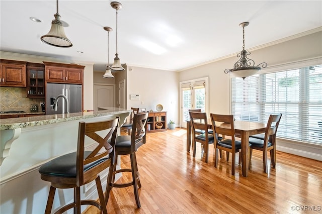 2220 French Hill Ter, Powhatan, VA 23139 - kitchen with stainless steel fridge, a kitchen breakfast bar, light wood finished floors, and crown molding