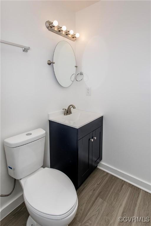 321 Porterville St, Petersburg, VA 23803 - half bathroom with wood finished floors, vanity, toilet, and baseboards