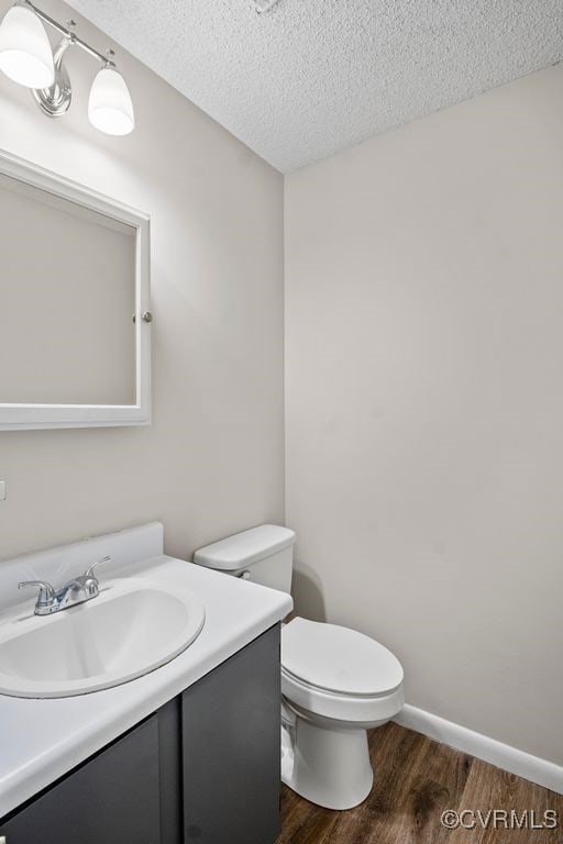 9548 Bent Wood Ln, North Chesterfield, VA 23237 - bathroom with vanity, wood finished floors, toilet, a textured ceiling, and baseboards