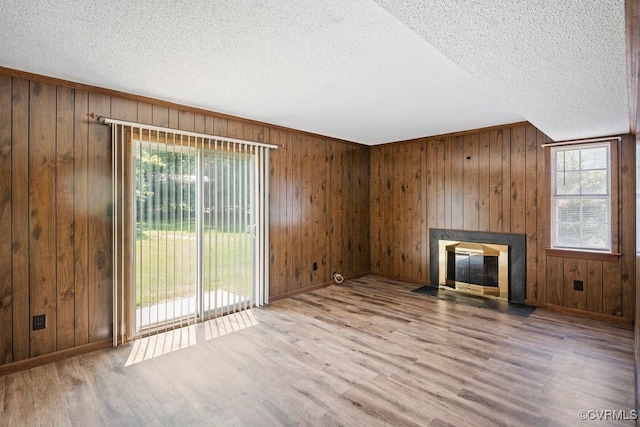 9548 Bent Wood Ln, North Chesterfield, VA 23237 - unfurnished living room featuring wood finished floors, a fireplace with flush hearth, wooden walls, a textured ceiling, and baseboards