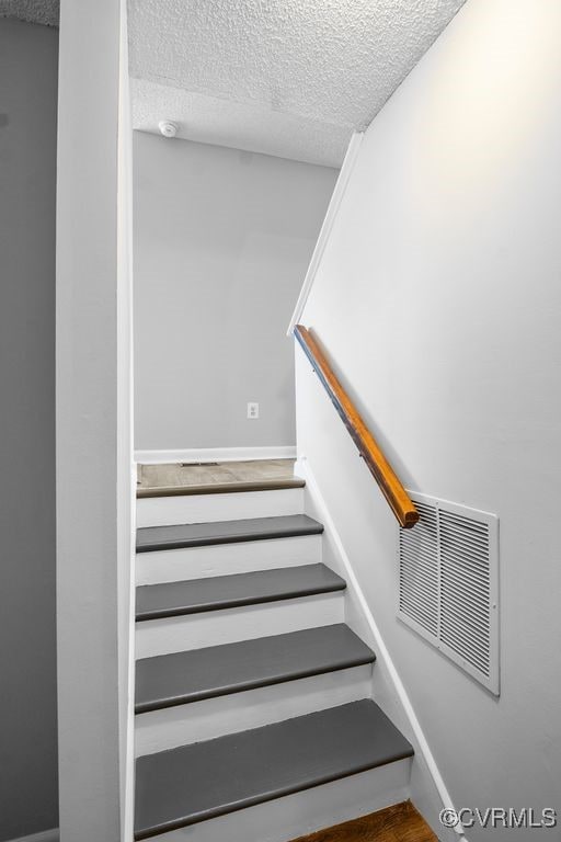 9548 Bent Wood Ln, North Chesterfield, VA 23237 - stairway featuring a textured ceiling, wood finished floors, and baseboards