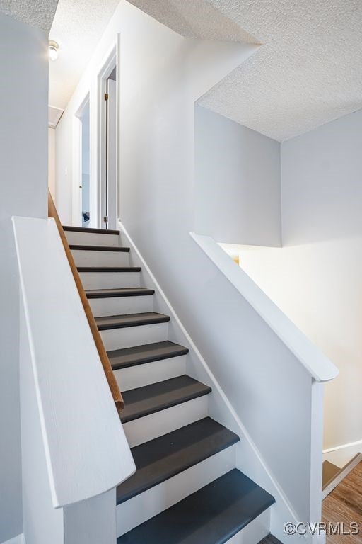 9548 Bent Wood Ln, North Chesterfield, VA 23237 - stairs featuring a textured ceiling and wood finished floors