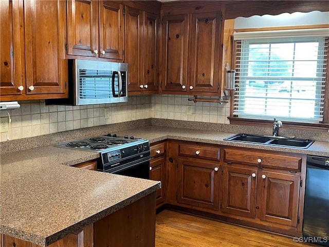 8172 Dunfee Ln, Mechanicsville, VA 23111 - kitchen featuring stainless steel appliances, a sink, decorative backsplash, light wood-style floors, and brown cabinets