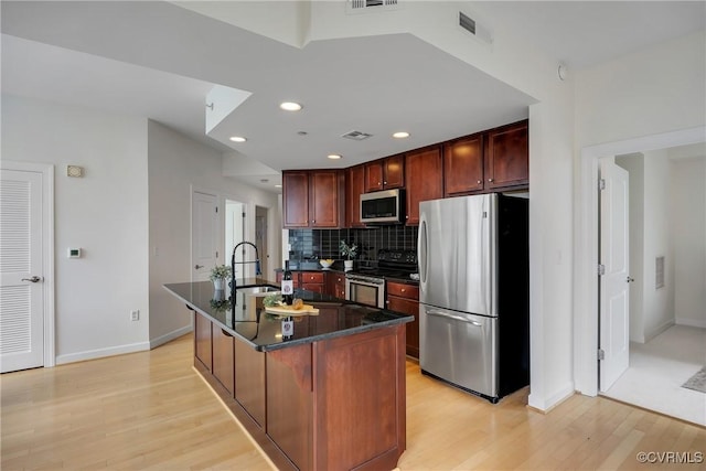 1101 Haxall Pt Unit U1001, Richmond, VA 23219 - kitchen with stainless steel appliances, a sink, light wood finished floors, backsplash, and baseboards