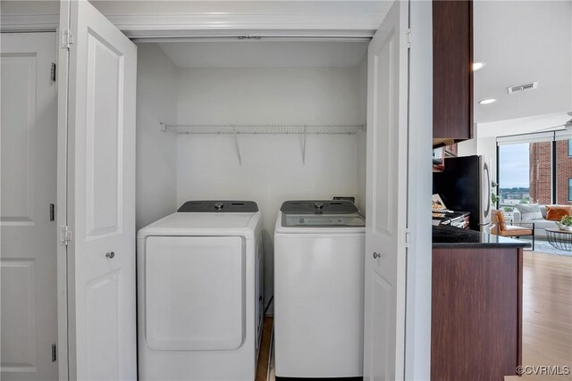 1101 Haxall Pt Unit U1001, Richmond, VA 23219 - washroom with washing machine and dryer and light wood-type flooring
