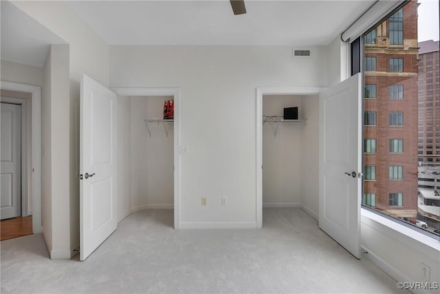 1101 Haxall Pt Unit U1001, Richmond, VA 23219 - unfurnished bedroom featuring light colored carpet, baseboards, a ceiling fan, and a spacious closet
