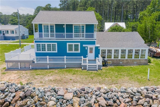 154 Riverside Dr, Deltaville, VA 23043 - view of front of house with a balcony, roof with shingles, a deck, a front lawn, and brick siding