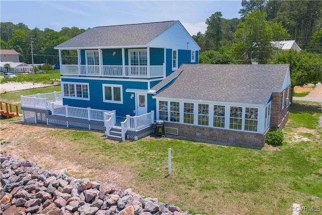154 Riverside Dr, Deltaville, VA 23043 - back of property featuring a balcony, a yard, brick siding, a deck, and a shingled roof