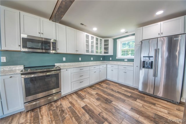 154 Riverside Dr, Deltaville, VA 23043 - kitchen with appliances with stainless steel finishes, dark wood-type flooring, glass insert cabinets, white cabinets, and recessed lighting
