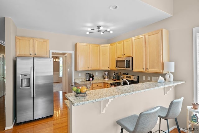 14825 Windjammer Dr, Midlothian, VA 23112 - kitchen with appliances with stainless steel finishes, light brown cabinets, and a breakfast bar area