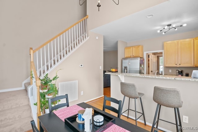 14825 Windjammer Dr, Midlothian, VA 23112 - kitchen featuring stainless steel fridge with ice dispenser, light brown cabinetry, a breakfast bar, and a peninsula