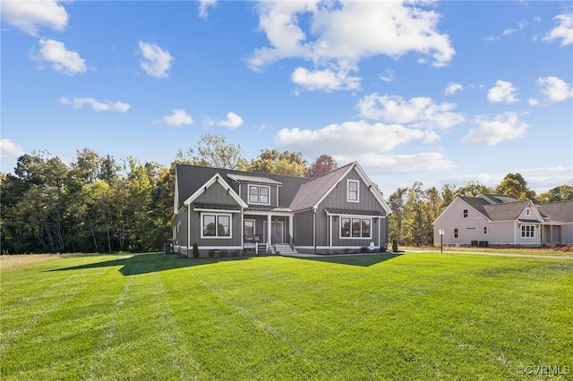 9463 Angels Share Dr, New Kent, VA 23124 - view of front of home featuring board and batten siding, a front lawn, a standing seam roof, and metal roof