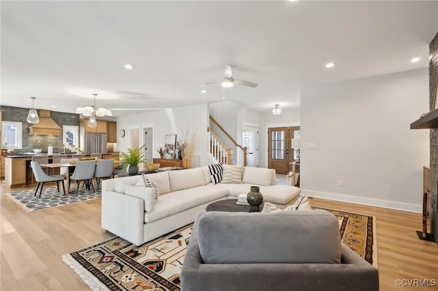 9463 Angels Share Dr, New Kent, VA 23124 - living area with stairs, a large fireplace, recessed lighting, light wood-style floors, and a chandelier