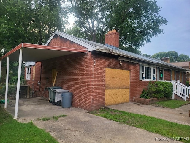 72 Cline Dr, Newport News, VA 23666 - view of side of home featuring a chimney, brick siding, and concrete driveway